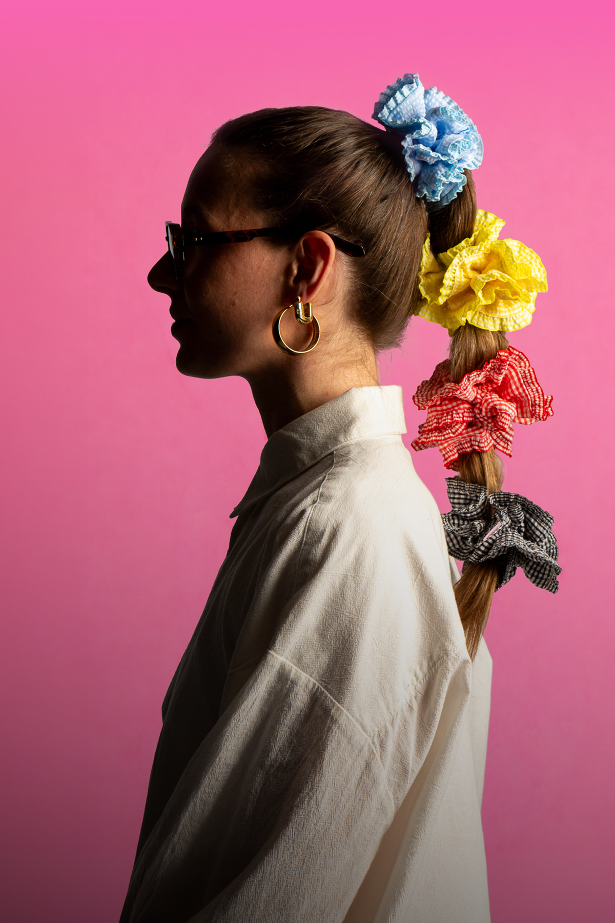 banner met dame die vier scrunchies in haar haar draagt met witte blouse en bril