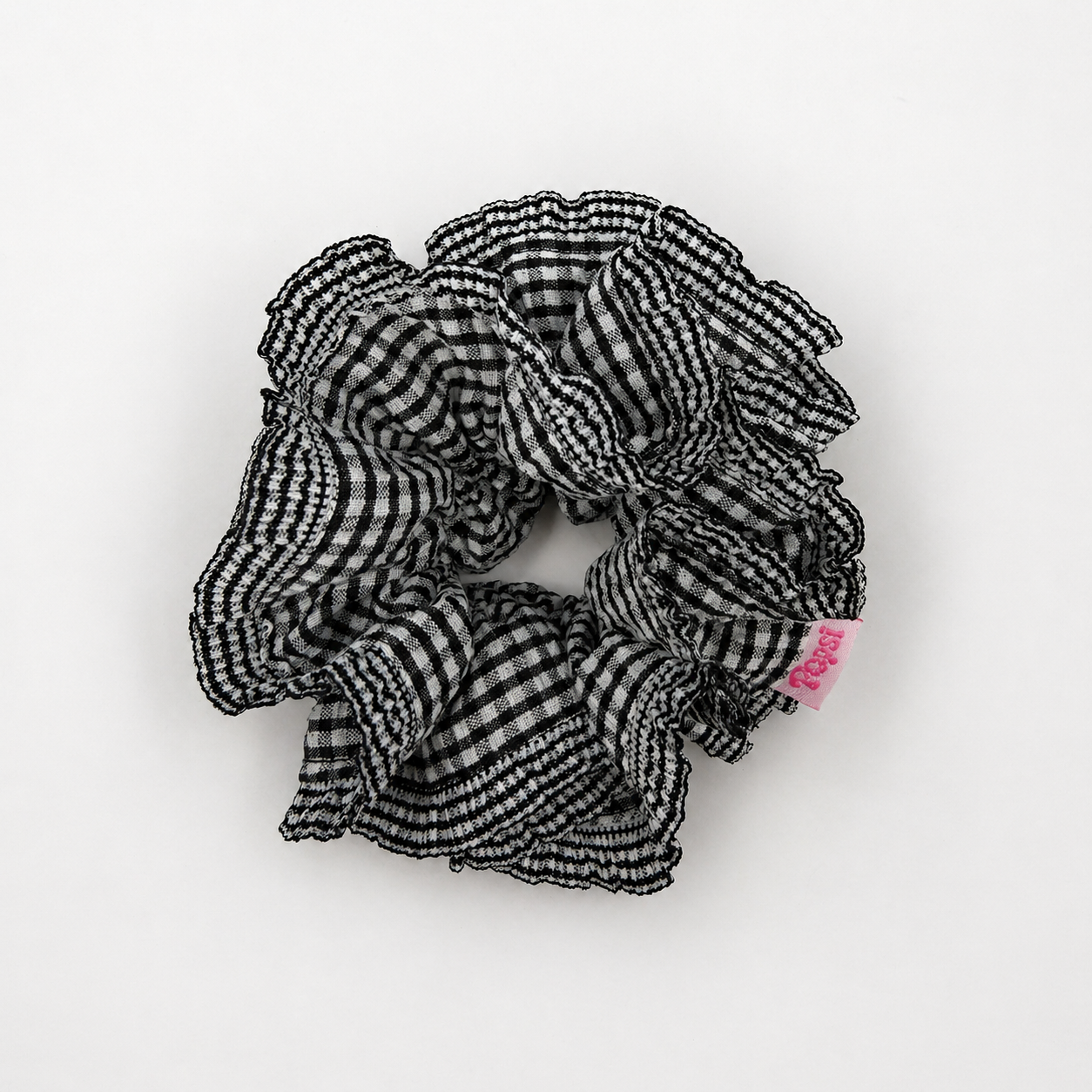 Productfoto van een zwartwitte scrunchie met ruitjes op een witte achtergrond