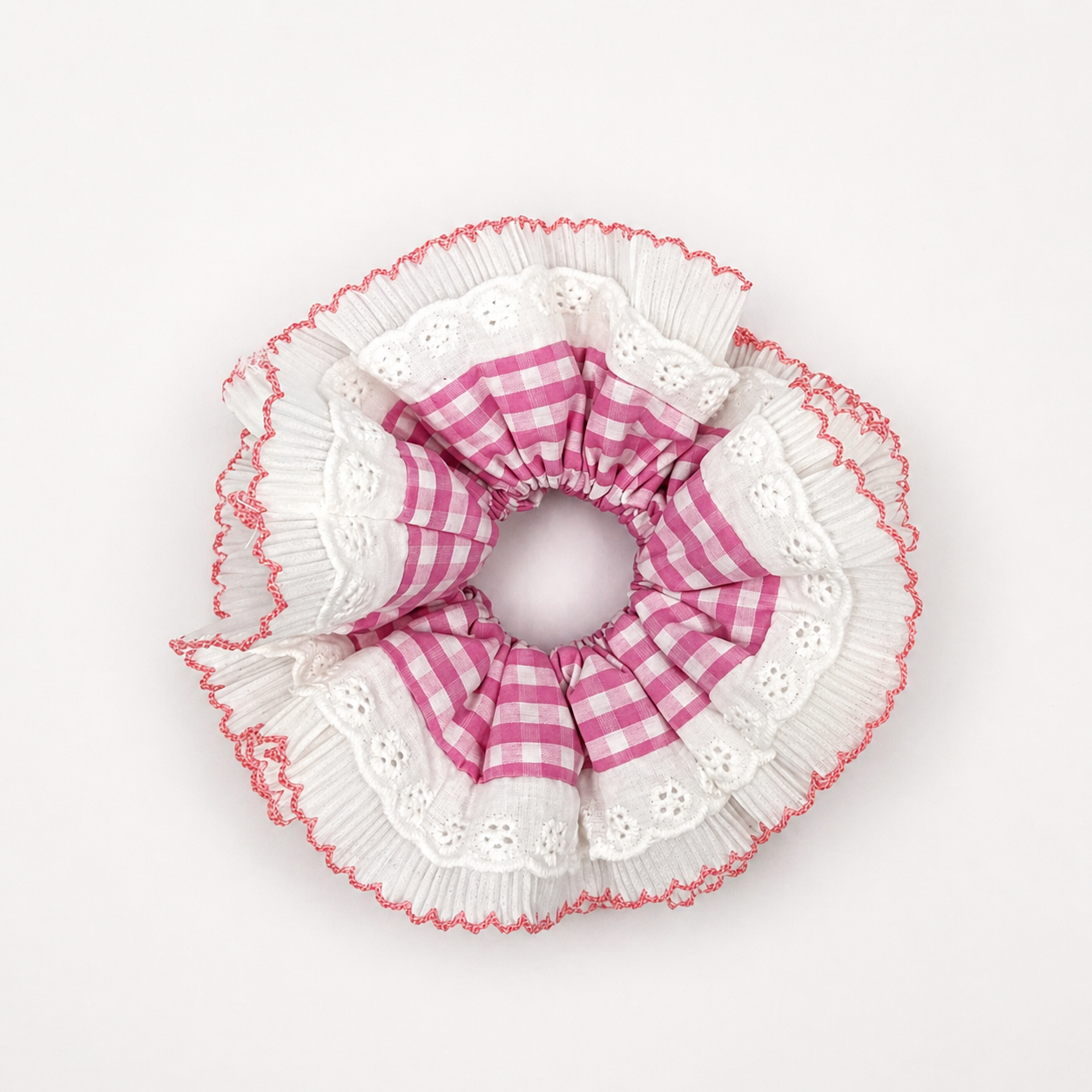 Productfoto van een wit met roze scrunchie met kant op een witte achtergrond