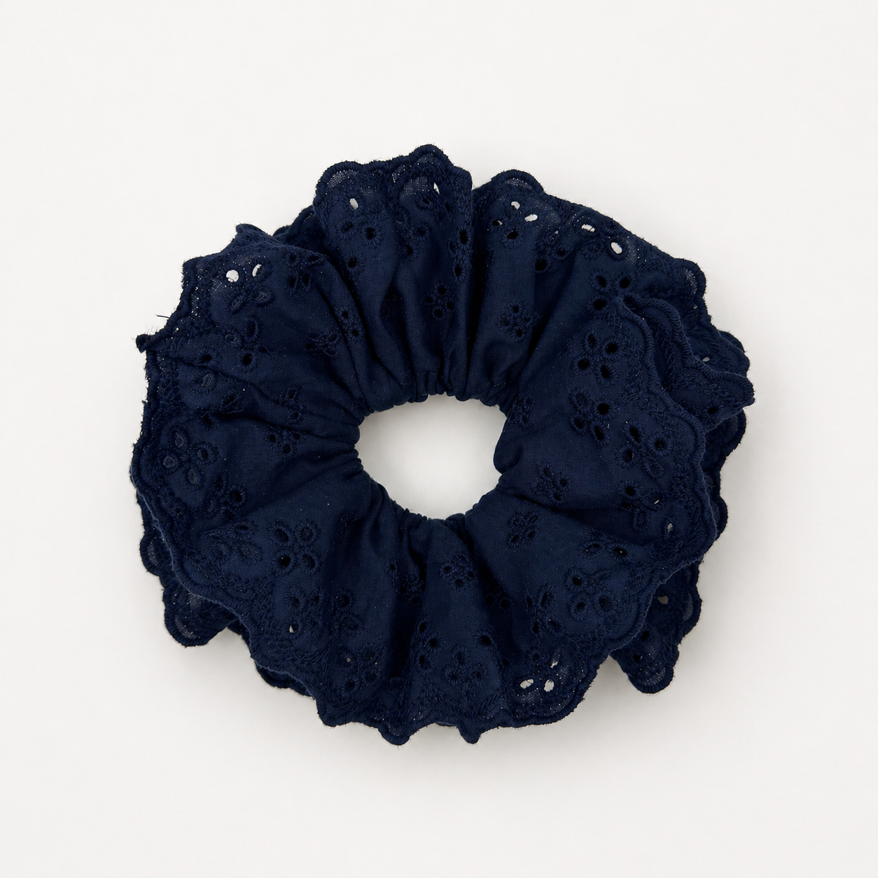 Productfoto van een donkerblauwe scrunchie met kant op een witte achtergrond