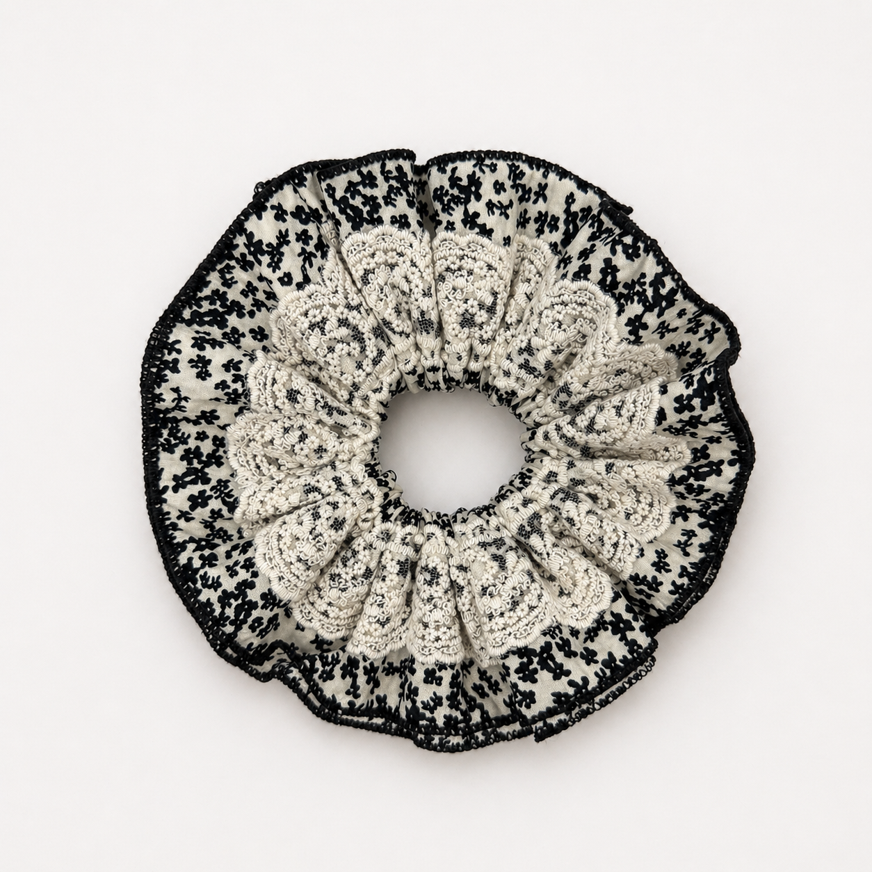 productfoto van een zwart wit kanten scrunchie op een witte achtergrond